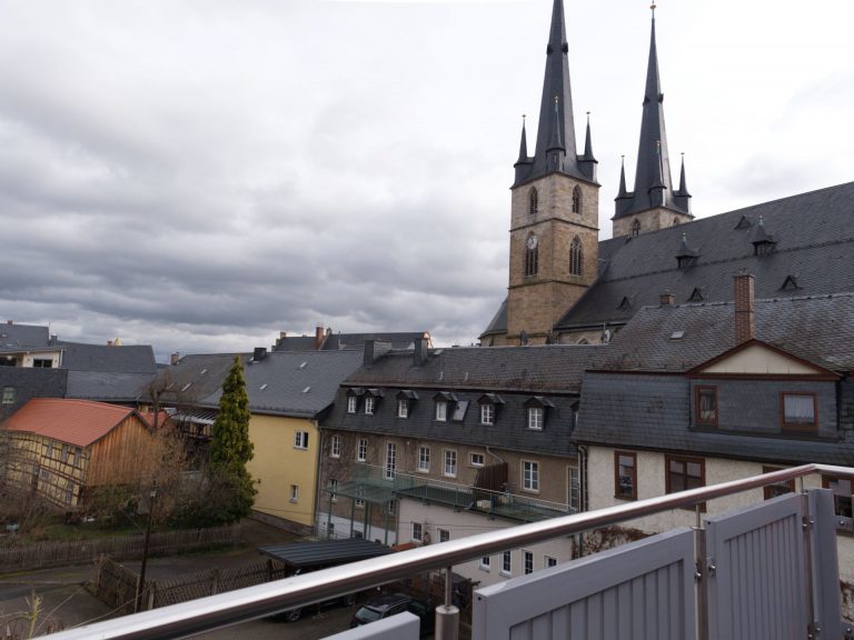 Ausblick von der Terrasse auf eine Kirche.