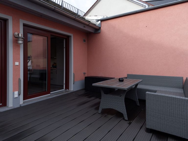 Terrasse mit Tisch und Sitzgelegenheiten.