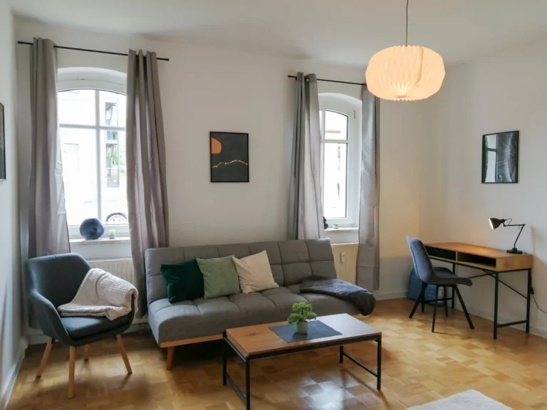Sofa, Sessel, Couch-Tisch und Schreibtisch im Apartment Südstadt Wohnzimmer.